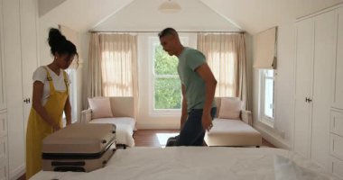 Çeşitli çiftler bavullarını parlak yatak odasında topluyor ve evde seyahat macerasına hazırlanıyorlar. tatil, planlama