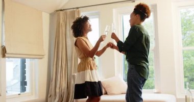 Çeşitli lezbiyen çiftler ellerinde şampanya bardaklarıyla evde neşeyle dans ediyorlar. Kutlama, dans, parti, mutluluk, eğlence, arkadaşlık