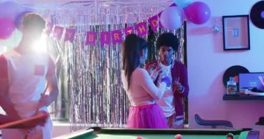 Parti dekoru çeşitli arkadaşları şeker dolduruyor, bilardo oynuyor ve dinlenme odasındaki telefonları kontrol ediyor. Kutlama, dostluk, eğlence, coşku, sosyal, renkli, eğlence