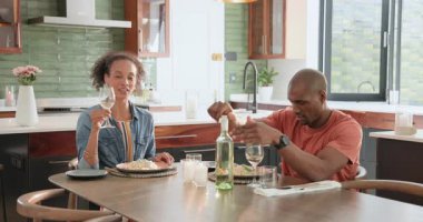 Çeşitli çiftler evde kutlama yapıyor, mutfakta şarapla yemeğin tadını çıkarıyorlar. Kutlama, romantizm, mutluluk, yaşam tarzı, bağ