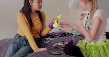 Yatakta mor keseyi açan, eldivenleri değiş tokuş eden ve telefon özçekim yapan çeşitli bayan arkadaşlar. Arkadaşlık, kahkaha, neşeli, gündelik, canlı, modern, yaşam tarzı