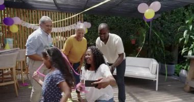 Doğumgününü dışarıda kutlamak, farklı ailelerin neşeli anlarını akıllı telefonlarla birlikte yakalamak. Kutlama, birliktelik, mutluluk.