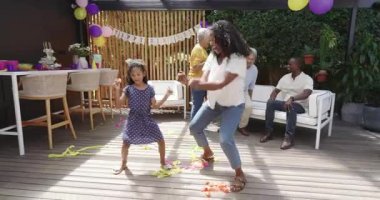 Anne ve kızı çeşitli aile kutlamalarında flamalarla dans ediyorlar. dans, birliktelik, açık hava etkinliği, kaynaşma