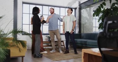 Meslektaşlar, modern ofis ortamında grup kucaklaşmasıyla başarıyı kutluyorlar. Takım çalışması, işbirliği, başarı, şirket, kutlama, iş arkadaşları