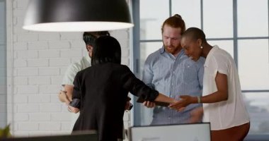 Muhtelif meslektaşlar ofiste başarıyı kutluyor, tableti tutuyor ve heyecanı paylaşıyor. Takım çalışması, işbirliği, başarı, kutlama, iş dünyası, teknoloji