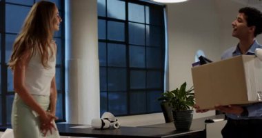 Ofisteki çeşitli meslektaşlar, ofis malzemeleriyle dolu kutuları açarken gülümsüyorlar. Takım çalışması, işbirliği, işyeri, taşınma, takım çalışması, işbirliği