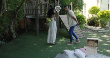 Adam bahçede kadına evlenme teklif ediyor, yüzükle diz çöküyor, doğayla iç içe. Evlilik teklifi, romantizm, nişan, aşk, farklı çiftler, bahçede