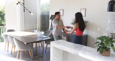 Dönen farklı çiftler, parlak mutfaktaki mermer mutfak adasının yanında meyve kasesiyle süzülüyorlar. Romantik, bağlantı, neşe, çağdaş, yaşam tarzı, iç mekan, mutluluk