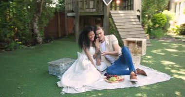 Çeşitli çiftler piknik battaniyesinde meyve tabağıyla selfie çekiyorlar, bahçede eğleniyorlar. Bahçede, yazda, rahatlamada, yaşam tarzında, boş vakitlerde, doğada