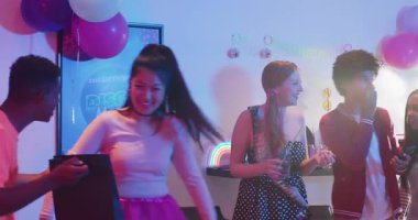 Kıvırcık saçlı adam telefonu gösteriyor, hediye paketini açıyor, doğum günü öpücüğünü bilardo masasında yakalıyor. Kutlama, dostluk, neşe, parti, sosyal, eğlence, coşku