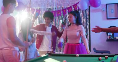 Çeşitli arkadaşlar, bilardo masasında doğum günü dansı için mikrofon uzatıyor, top atıyor ve pamuk şeker atıyor. Kutlama, yoldaşlık, eğlence, eğlence, eğlence, canlı, sosyal, eğlenceli