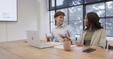 Meslektaşım ofiste dikkatle dinlerken iş adamı verileri ekranda sunuyor. Toplantı, sunum, şirket, takım çalışması, iletişim, profesyonel