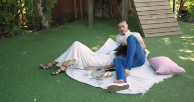 Parkta dinlenen, çeşitli çiftler, meyve ve içeceklerle battaniyede pikniğin tadını çıkarıyorlar. Bahçede, boş zaman, romantizm, doğa, rahatlama, yaşam tarzı