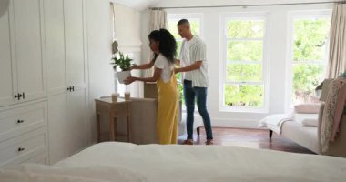 Çeşitli çiftler kutularını açıyor ve evdeki parlak oturma odasına resim çerçevesi asıyorlar. Taşınma, aile, ev, dekorasyon, yer değiştirme, iç mekan