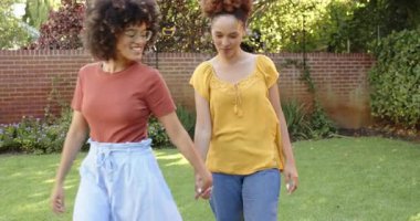 Çimlerin üzerinde piknik yapan kadınlar, bir içme suyu, ikisi de arka bahçede dinleniyor. Boş zaman, doğa, susuzluk, yaz, arkadaşlık, yaşam tarzı