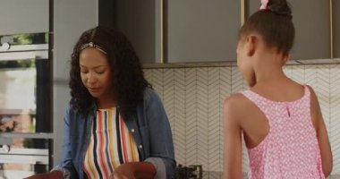 Anne ve kızı modern mutfakta salata hazırlıyor, çeşitli aile zamanlarının tadını çıkarıyor, evde. Yemek, sağlıklı beslenme, bağlanma, yaşam tarzı, ev, beslenme