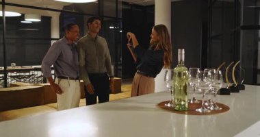 İş adamı ofis partisinde içki koyarken çeşitli meslektaşları etrafında sosyalleşiyor. Şirket, kutlama, ağ, sosyalleşme, işyeri, çeşitlilik