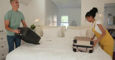 Çeşitli çiftler yatak odasında bavullarını topluyor, tatillerine hazırlanıyorlar, evde. Seyahat, ilişki, bagaj, tatil, hazırlık, turizm
