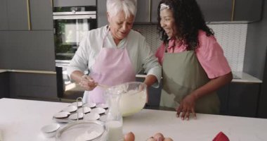 Kek pişirmek, büyükanne ve çocuğun modern mutfakta kahkahalarını paylaşmak. Çeşit çeşit aile, bağ, nesiller arası, mutluluk, yemek, aşçılık