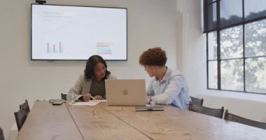 Ofiste, çeşitli meslektaşlar sunum ekranında dijital evlat edinme eğilimlerini tartışıyor. İş, takım çalışması, işbirliği, teknoloji, konferans, strateji