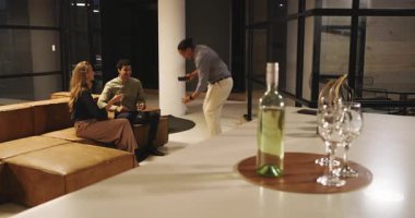 Çeşitli meslektaşlar geceleri modern ofis salonunda içki içip sohbet ediyorlar. İş, iş arkadaşları, ağ kurma, sosyalleşme, çeşitli takımlar, akşam