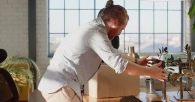 Muhtelif meslekdaşlar ofis taşınmasını karton kutu ve bitkilerle tartışıyor. İş, taşınma, takım çalışması, işbirliği, çalışma alanı, geçiş