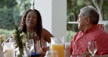 Çeşitli aileler, şarap kadehleriyle kadeh kaldıran yaşlı bir çift, birlikte dışarıda akşam yemeğinin tadını çıkarıyorlar, evde. Kutlama, romantizm, birliktelik