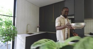 Çeşitli aileler modern mutfakta birlikte yemek hazırlar, sebze ve ekmek doğrarlar. Yemek pişirme, farklı aile zamanları, takım çalışması, ev, yaşam tarzı, sağlıklı beslenme.