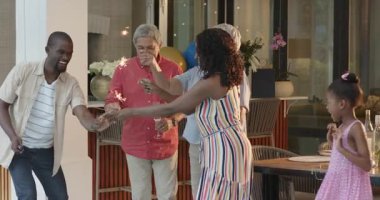 Evde, şenlikli bir anda çeşitli ailelerin gülümsediği havai fişeklerle kutluyoruz. Kutlama, tatil, neşe, birliktelik, mutluluk, gece