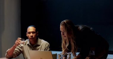 Ofis masasında dizüstü bilgisayar ve su sürahisi ile iş birliği yapan çeşitli profesyoneller. İşbirliği, takım çalışması, toplantı, beyin fırtınası, şirket, strateji