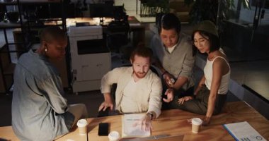 Muhtelif takımlar ofis masasında işbirliği yapıyor, çizelgeler ve kahve fincanlarıyla projeleri tartışıyorlar. İşbirliği, takım çalışması, beyin fırtınası, iş, planlama, strateji