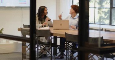 Kadın ve iş arkadaşı modern ofiste iş stratejisini tartışıyorlar. Takım çalışması, işbirliği, şirket, beyin fırtınası, çalışma alanı, planlama