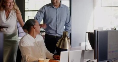 Ofiste işbirliği içinde, çeşitli meslektaşlar gülümseme ve coşkuyla projeyi tartışıyorlar. Takım çalışması, iş, işbirliği, beyin fırtınası, profesyonel, iş