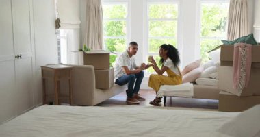 Çeşitli çiftler kutuları açıyor ve yeni evleri dekore ediyor. Parlak yaşam alanlarının tadını çıkarıyorlar. Taşınma, taşınma, ev dekorasyonu, iç dekorasyon, yaşam tarzı, yerli