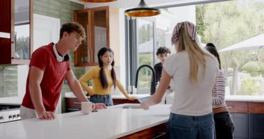 Farklı arkadaşlar mutfaktaki adaya arkadaş olarak yaslanıyorlar ellerinde kağıt okuyup, beşlik çakıyorlar. İşbirliği, sosyalleşme, modern, enerjik, neşeli, toplum, yaşam tarzı