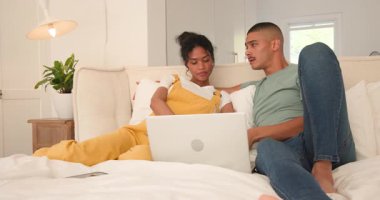 Çeşitli çiftler yatakta dizüstü bilgisayar izleyip evde rahat vakit geçiriyorlar. teknoloji, rahatlık, bağlanma, yaşam tarzı, rahatlık