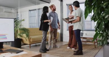 İş ekibi projeyi modern ofiste belgeler ve tabletle tartışıyor. Takım çalışması, işbirliği, şirket, teknoloji, toplantı, beyin fırtınası