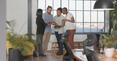 Çeşitli takımlar modern ofiste başarıyı beşlik çakarak ve gülümseyerek kutluyorlar. Takım çalışması, işbirliği, işyeri, çeşitlilik, başarı, pozitif