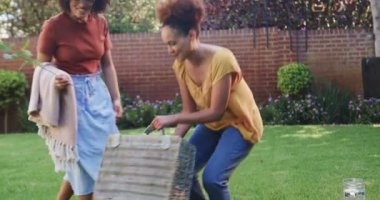 Aynı cinsiyetten farklı lezbiyen çiftler güneşli arka bahçede battaniyeyle oyun oynuyorlar. ilişki, açık hava, yaşam tarzı, mutluluk, LGBT, bağ