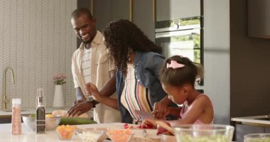 Çeşitli aileler modern mutfakta birlikte yemek hazırlar, evde kaliteli yemek pişirmenin tadını çıkarırlar. Yaşam tarzı, bağlılık, takım çalışması, hazırlık, aşçılık, birliktelik
