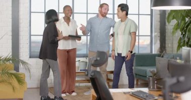 Ofisteki çeşitli meslektaşlar gündelik toplantı sırasında gülüyor ve fikirleri tartışıyor. Takım çalışması, işbirliği, beyin fırtınası, iş dünyası, tartışma, çeşitlilik