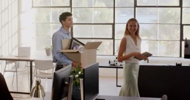 Çeşitli meslektaşlar modern ofiste kutuları açıyor, gülümsüyor ve yeni projeyi tartışıyorlar. Takım çalışması, işbirliği, iş yeri, işyeri, profesyonel, beyin fırtınası