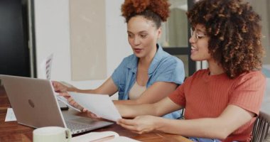 Evde işbirliği yapan, dizüstü bilgisayar kullanan ve not alan kadınlar projeye odaklandılar. İşbirliği, takım çalışması, beyin fırtınası, uzaktan çalışma, üretkenlik, iş