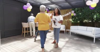 Elinde içki tutan ve çeşitli aile kutlamalarında balonlarla gülümseyen yaşlı bir adam. Mutluluk, açık hava, son sınıf, toplanma, şenlik