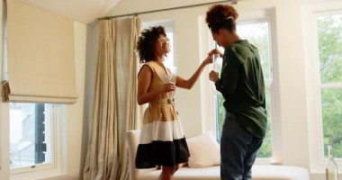 Aynı cinsiyetten farklı lezbiyen çiftler evde kutlama yapıyor, içki içip dans ediyorlar. LGBTQ, kutlama, mutluluk, ilişki, şenlik, parti