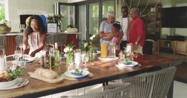 Çeşitli aile üyeleri evde toplanıyor, üç nesil birbirini sıcak bir şekilde selamlıyor ve gülümsüyor. birliktelik, nesiller arası bağ, birleşme, mutluluk, çok nesilli