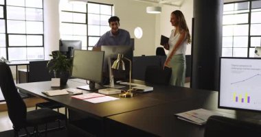 Çeşitli meslektaşlar modern ofiste projeyi tartışıyor, gülümsüyor ve belgeleri tutuyor. Takım çalışması, işbirliği, iş, profesyonel, kurumsal, toplantı