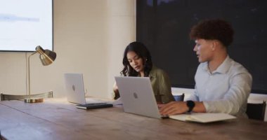 Kadın ve iş arkadaşı akşam toplantısı sırasında ofiste dizüstü bilgisayarlarla çalışıyor. İşbirliği, takım çalışması, beyin fırtınası, üretkenlik, teknoloji, çeşitli profesyoneller