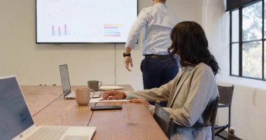 Modern ofisteki toplantı sırasında bilgisayardaki verileri analiz eden çeşitli iş adamları. takım çalışması, işbirliği, analitik, teknoloji, şirket, strateji