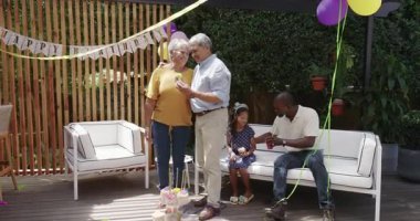 Doğumgününü dışarıda kutluyoruz, çeşitli aileler kek ve balonlarla neşeli anları paylaşıyoruz. Kutlama, mutluluk, toplanma, parti, şenlik, birliktelik